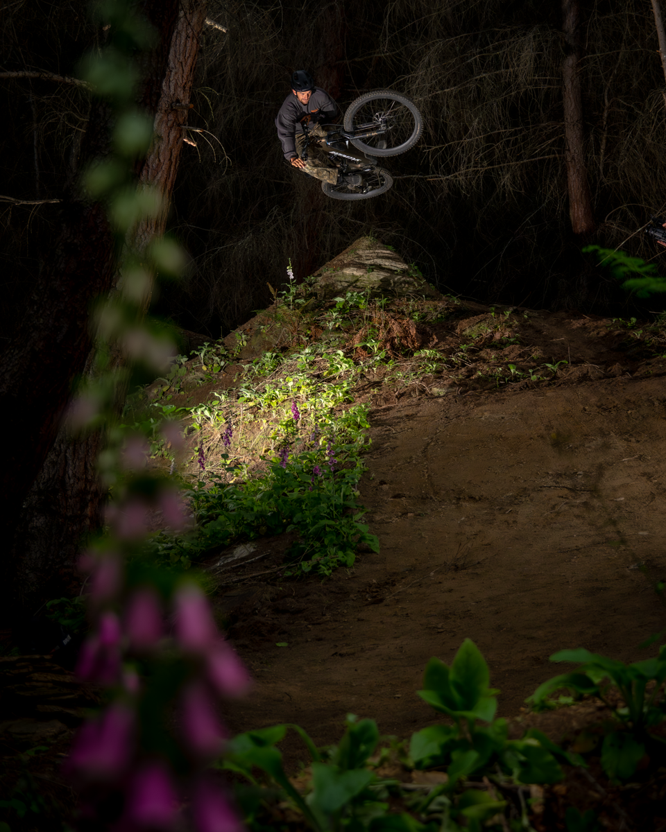 Person on a bike in a dark forest with a spotlight effect