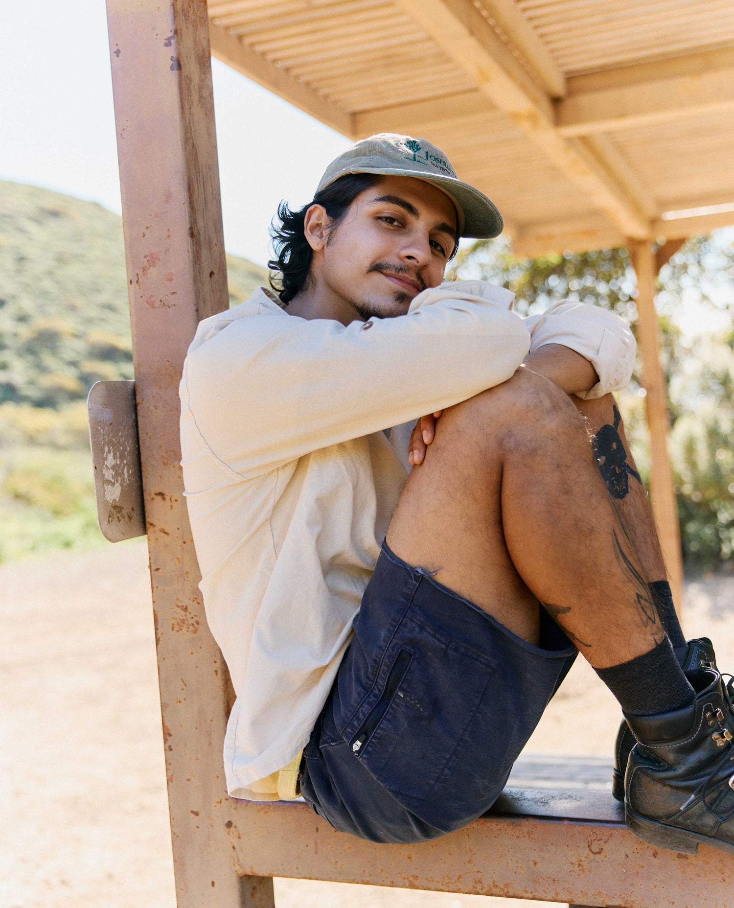 Man sitting on a wooden bench outdoors with a natural background