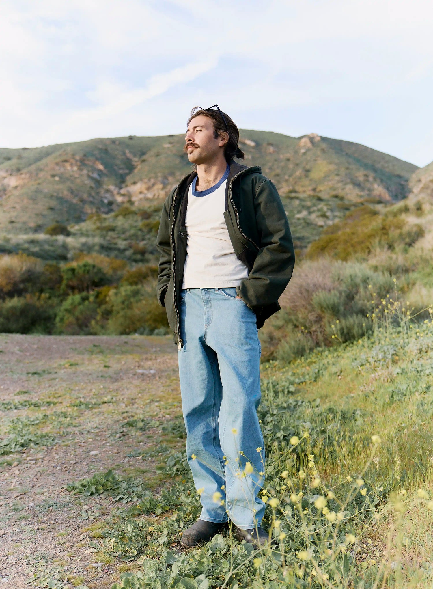 Man standing in a desert landscape with mountains in the background