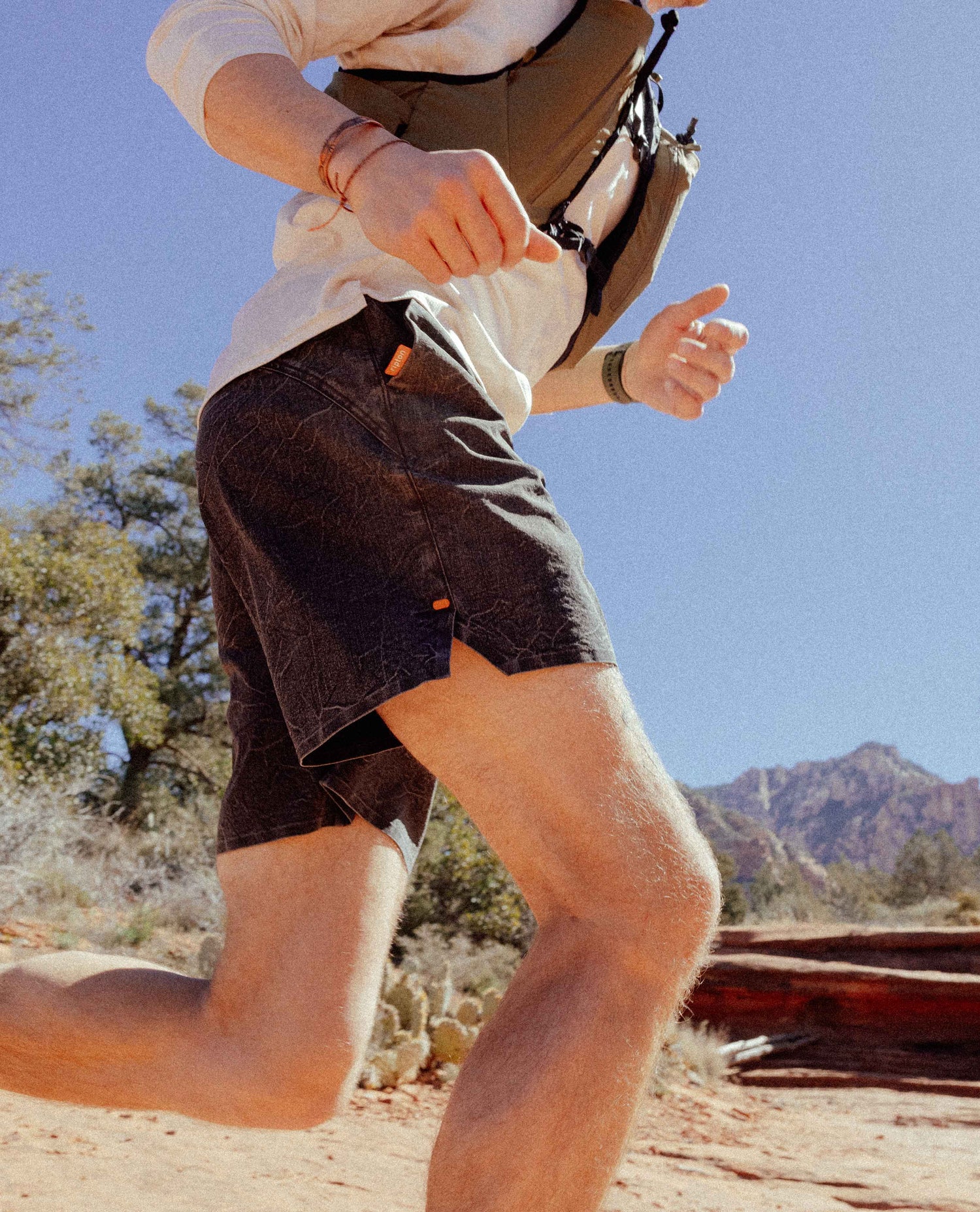 Person running outdoors with a backpack in a natural setting
