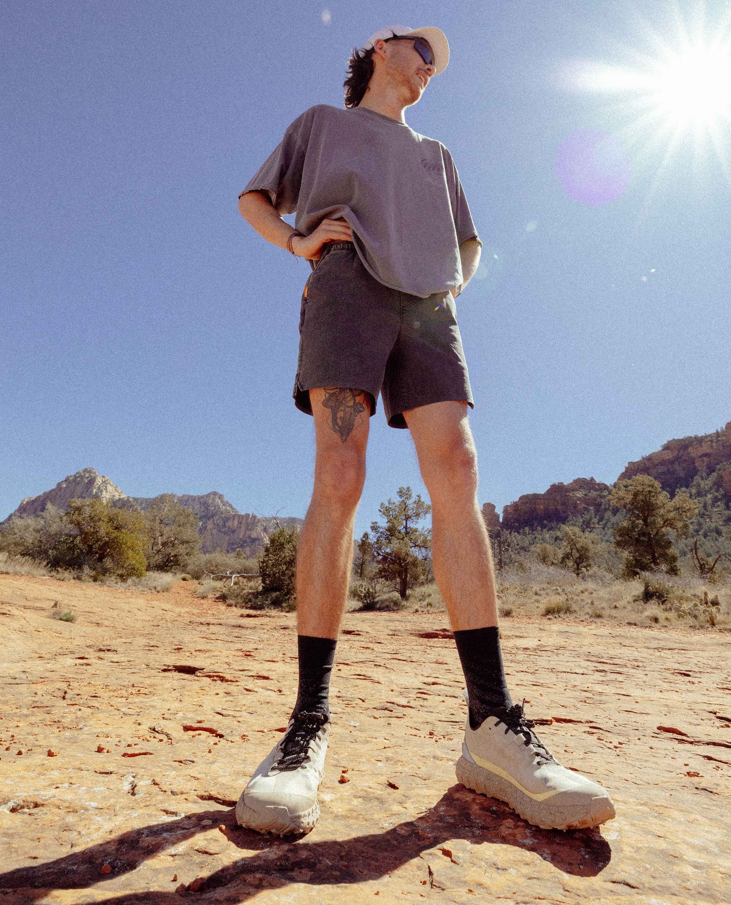 Person standing in a desert landscape with mountains in the background