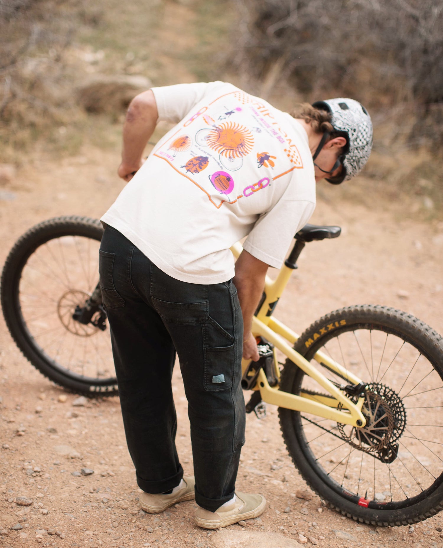 Callum wearing Black utility pants with his bike