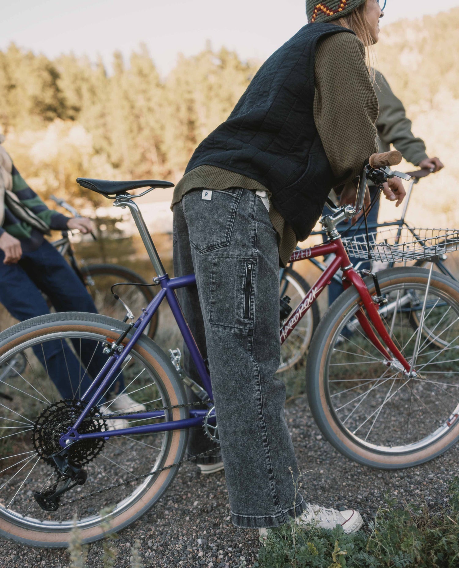 Person standing next to a bicycle with a scenic background