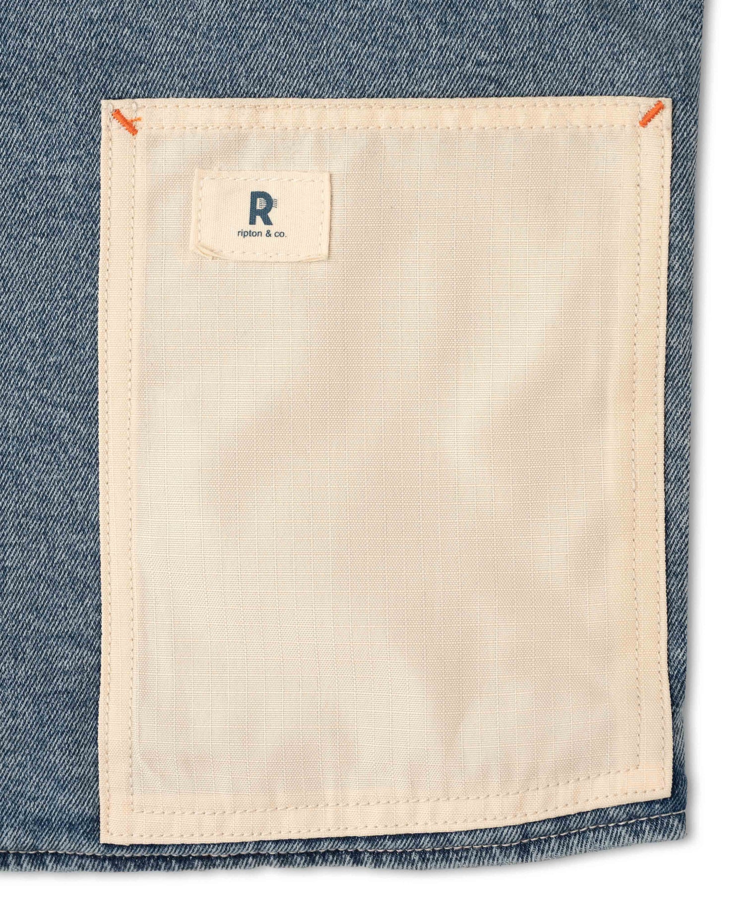 Close-up of a pocket on a denim garment with a brand label.