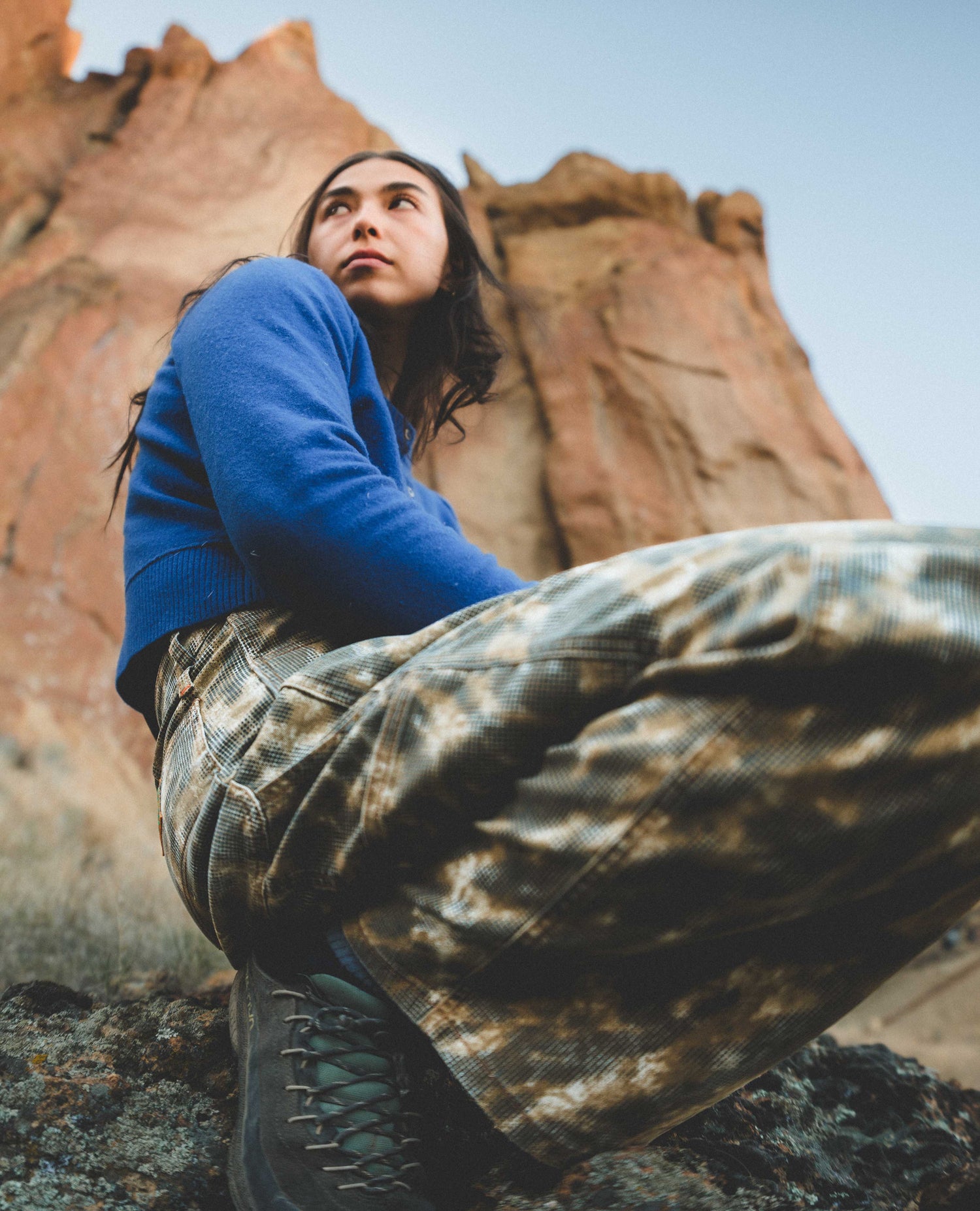 Person sitting on a rock with red rock formations in the background