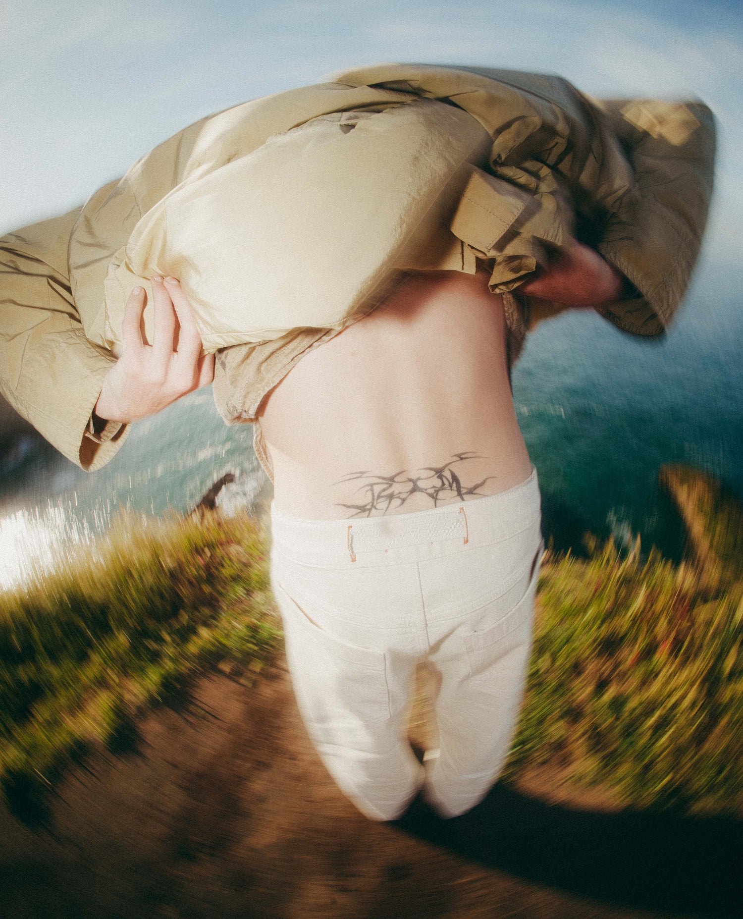 Person wearing a beige jacket with a scenic background