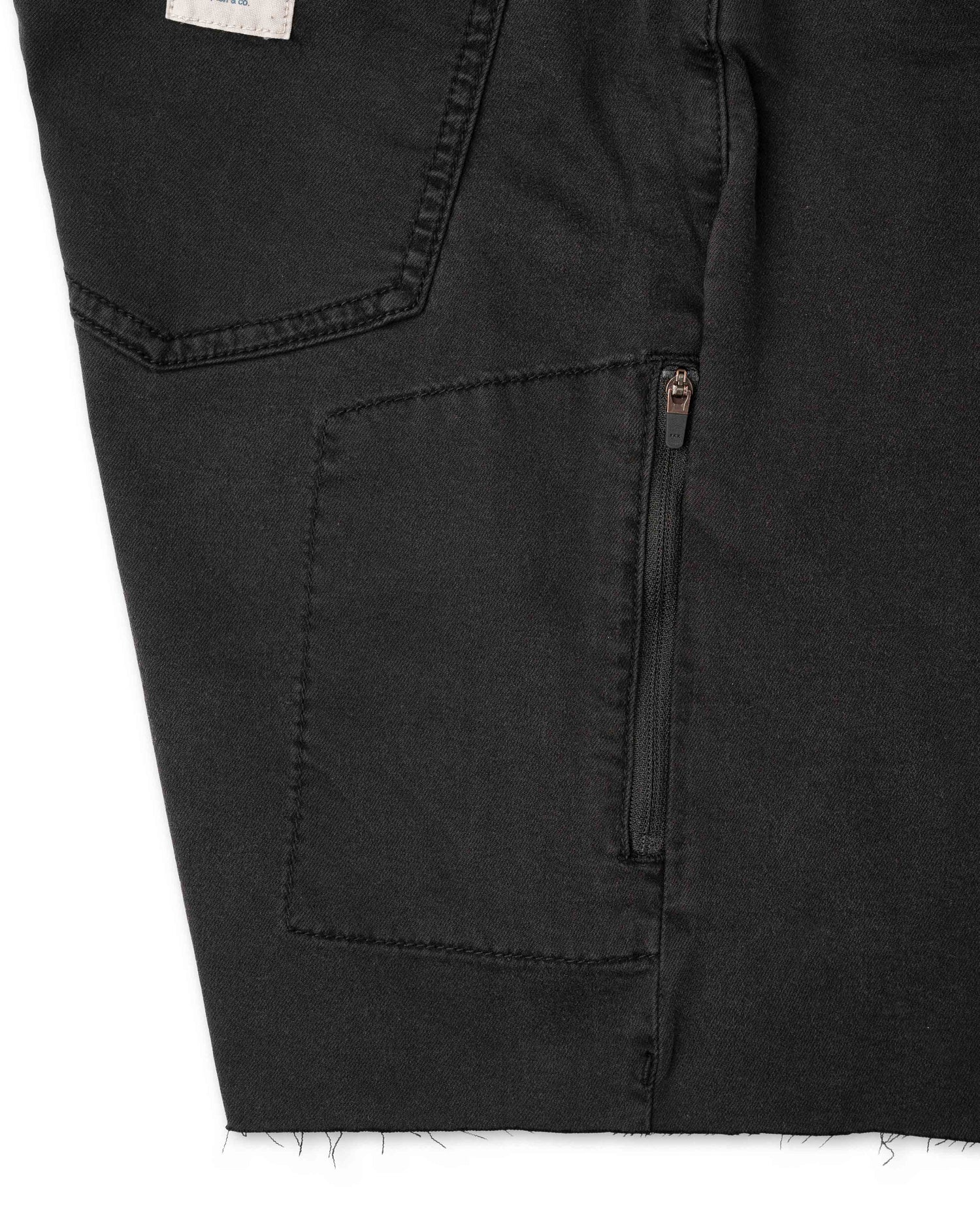Close up of pocket with zipper on black shorts with white background 