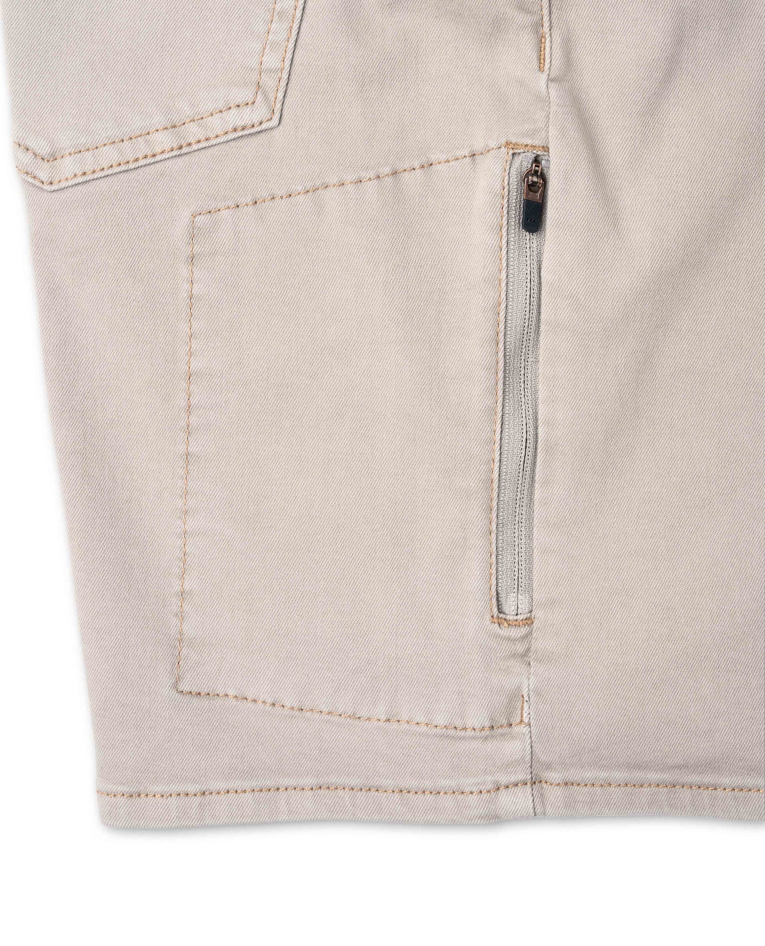 Close-up of beige shorts with a zipper on a white background