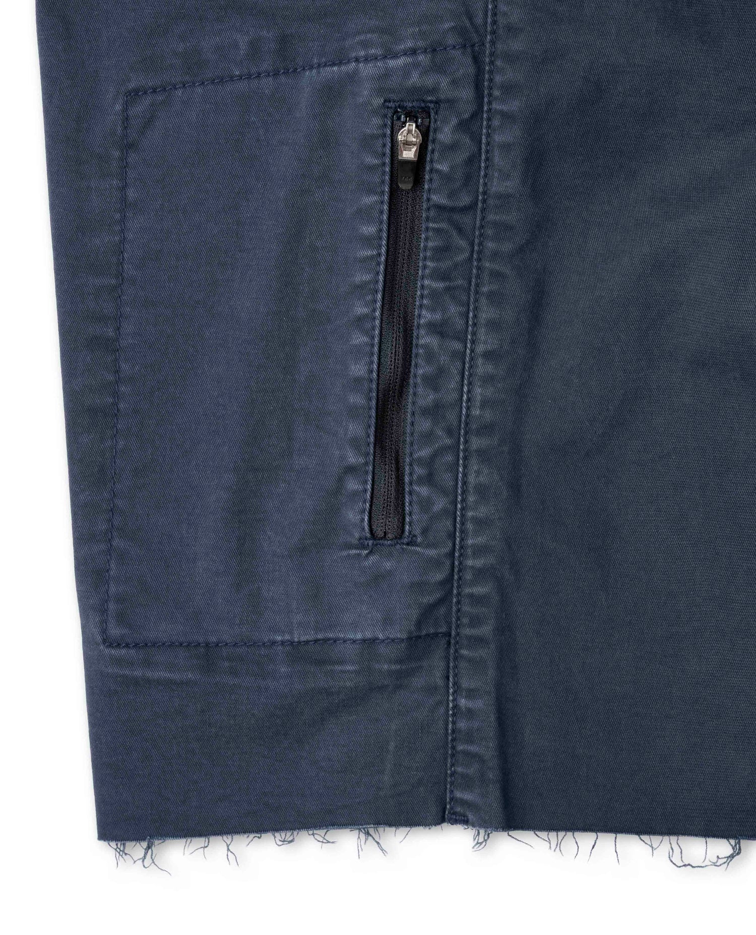 Close-up of a navy blue denim pocket with a zipper on a white background