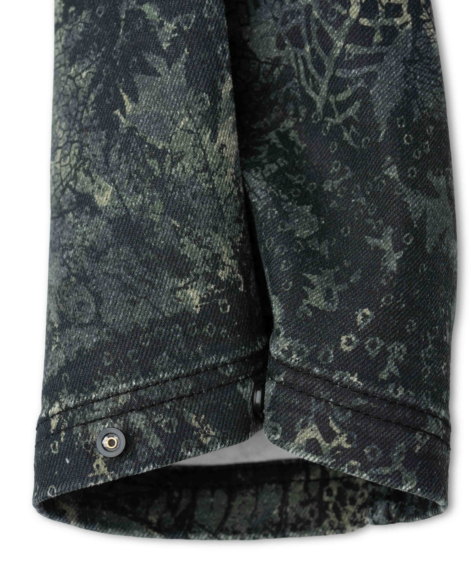 Cuff of camo pant snapped in tighter position