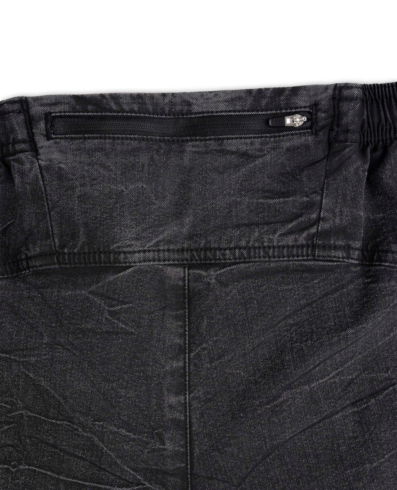Close-up of black pants with a zipper detail on a white background