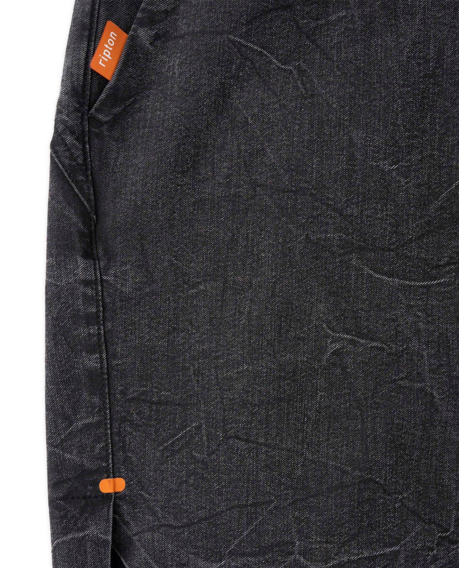 Close-up of a dark gray textured fabric with an orange brand label.
