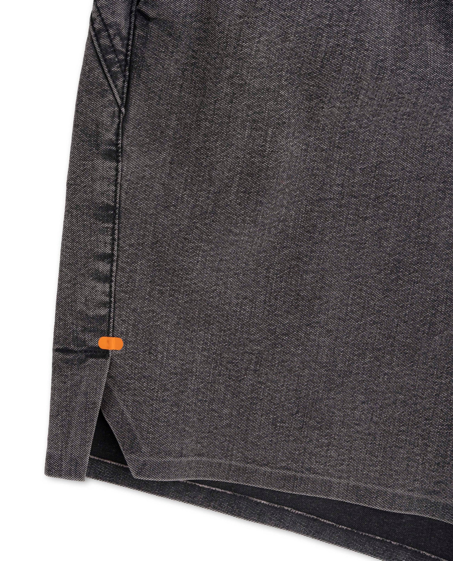 Close-up of a dark gray fabric with an orange tag on a white background