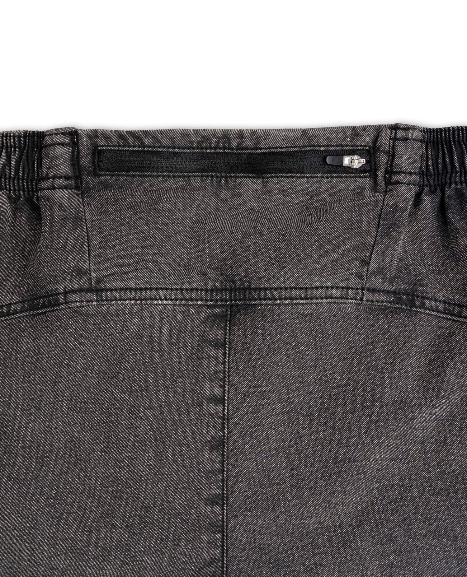 Close-up of a gray pants waistband with a zipper on a white background