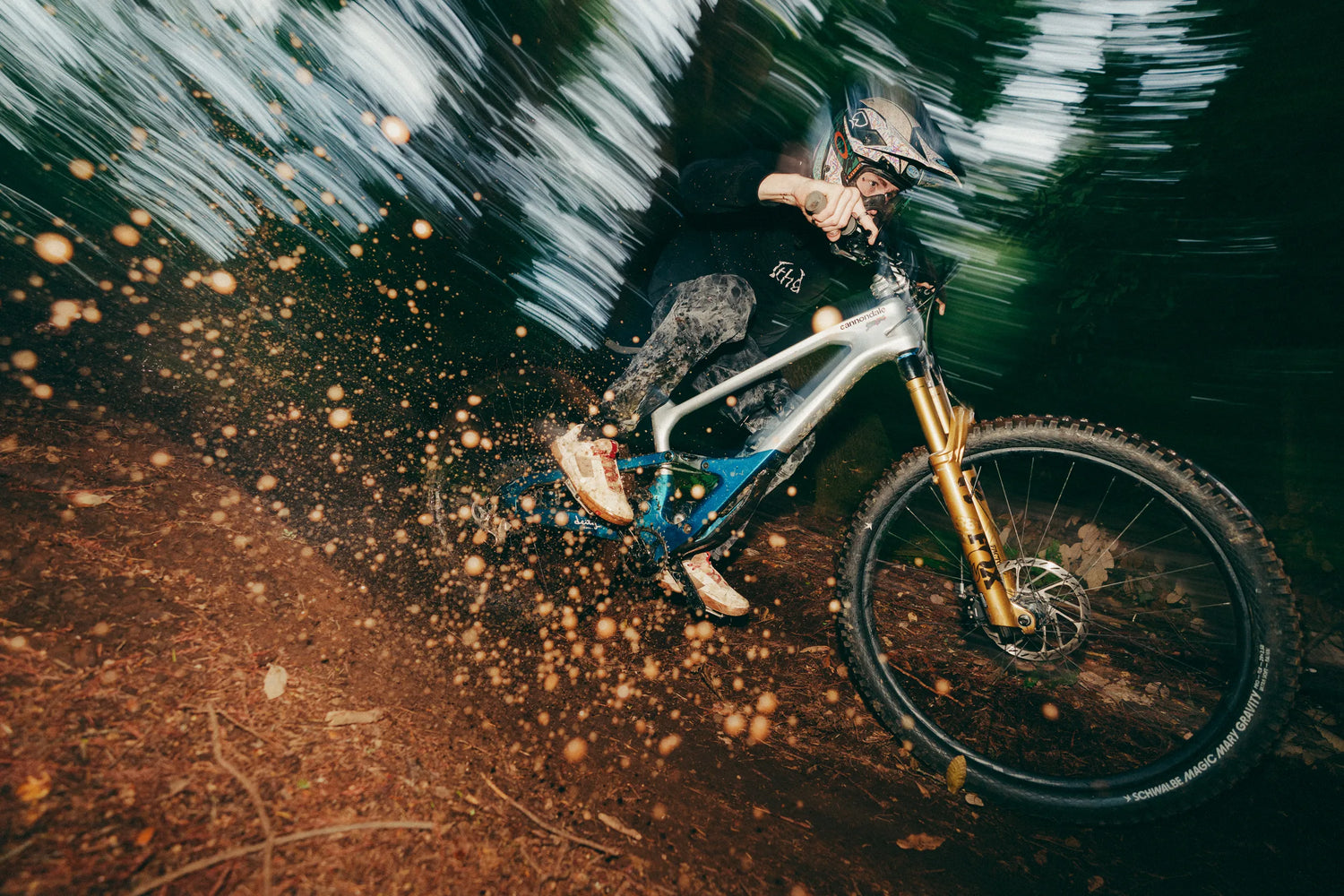 Biker in action on a dirt trail with splashes of water and mud.