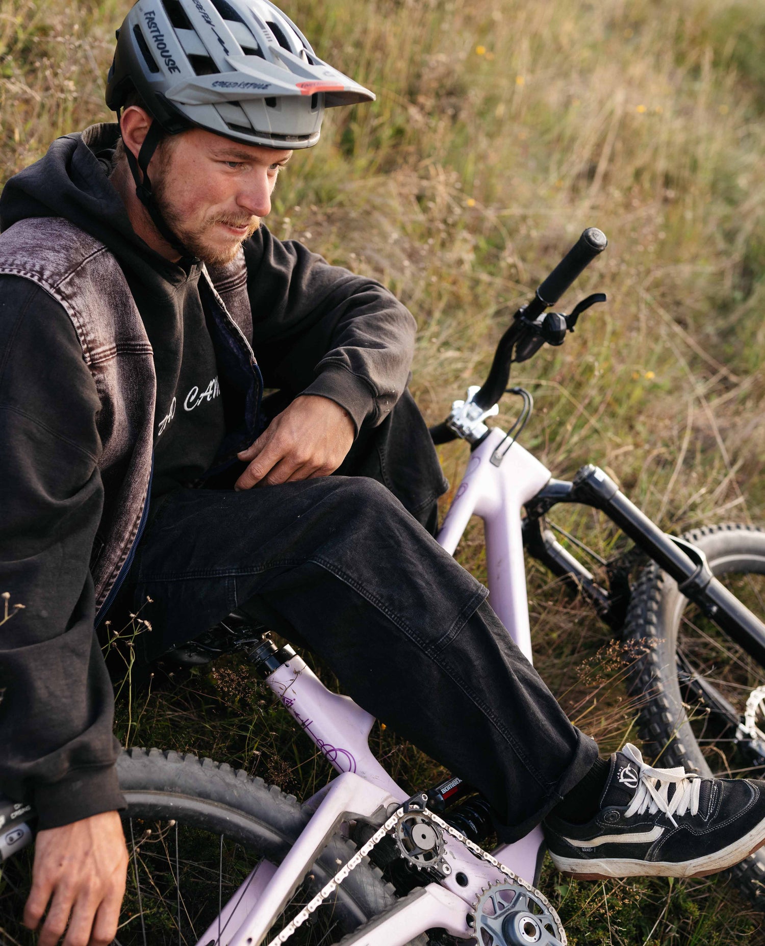 Man sitting on a bicycle in a grassy outdoor setting