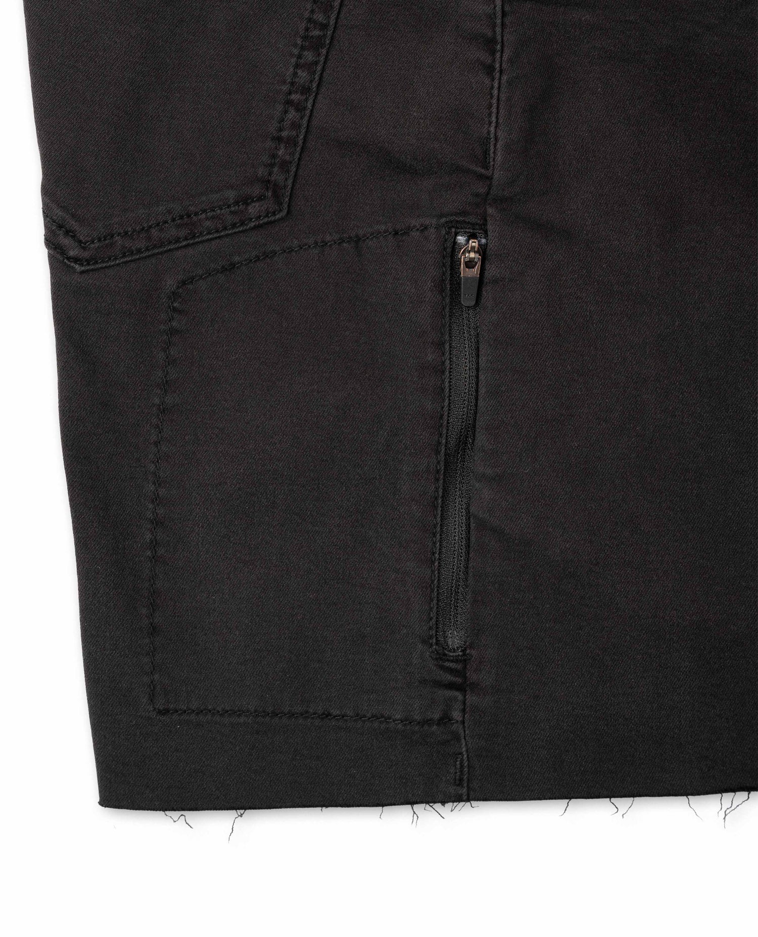 Close-up of a black denim pocket with a zipper on a white background