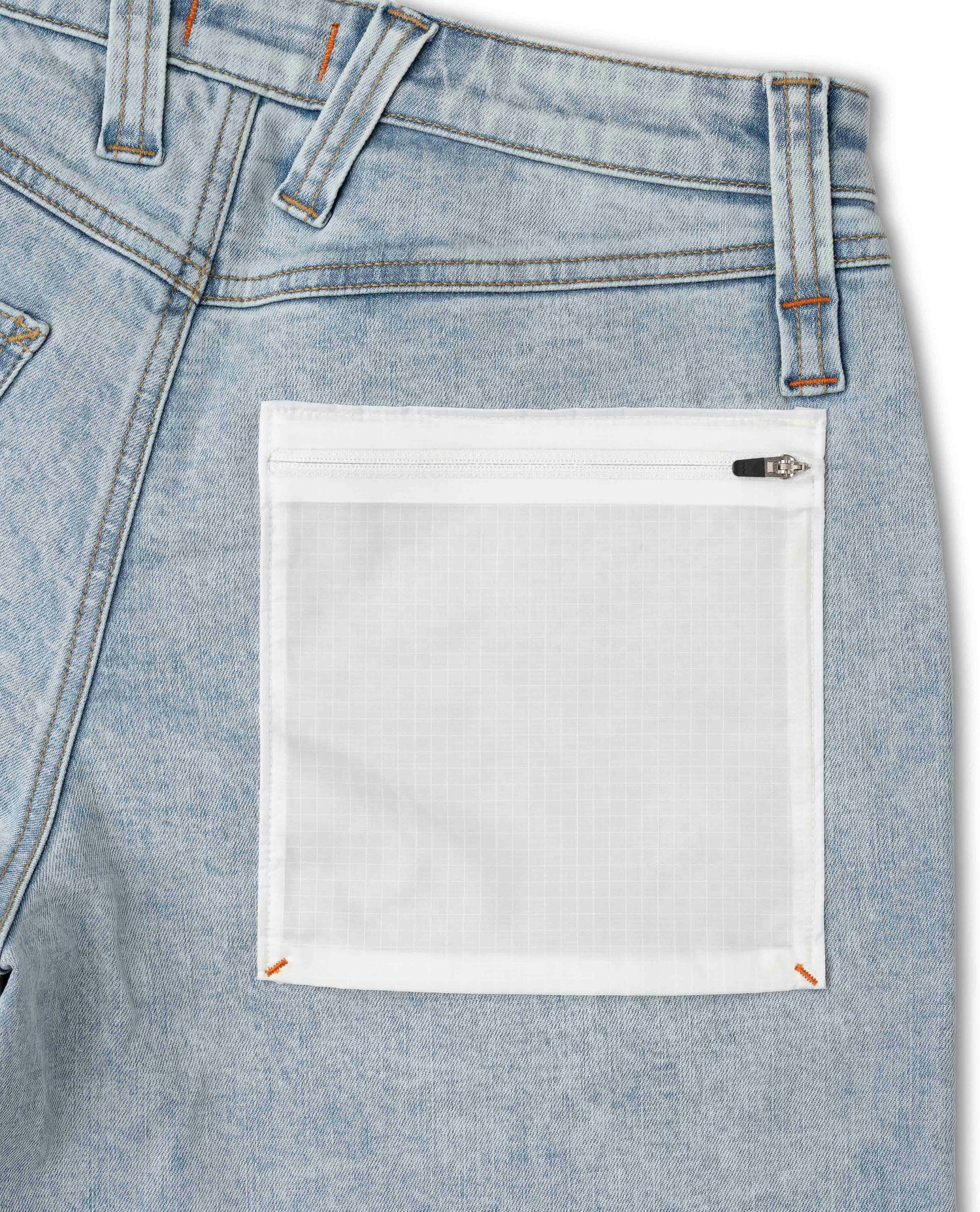 Close-up of a blue denim pocket with a white label.