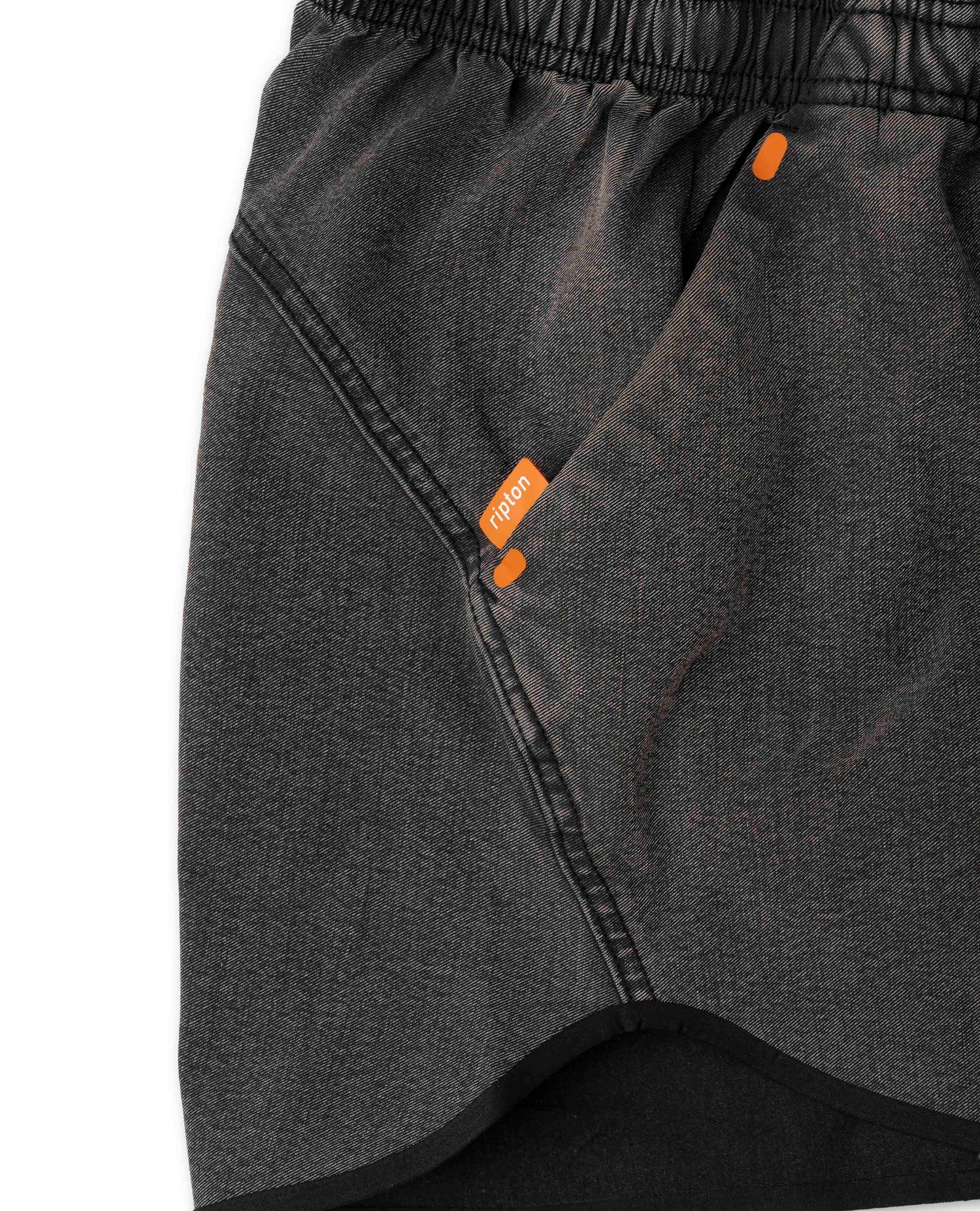 Close-up of dark gray shorts with orange accents on a white background