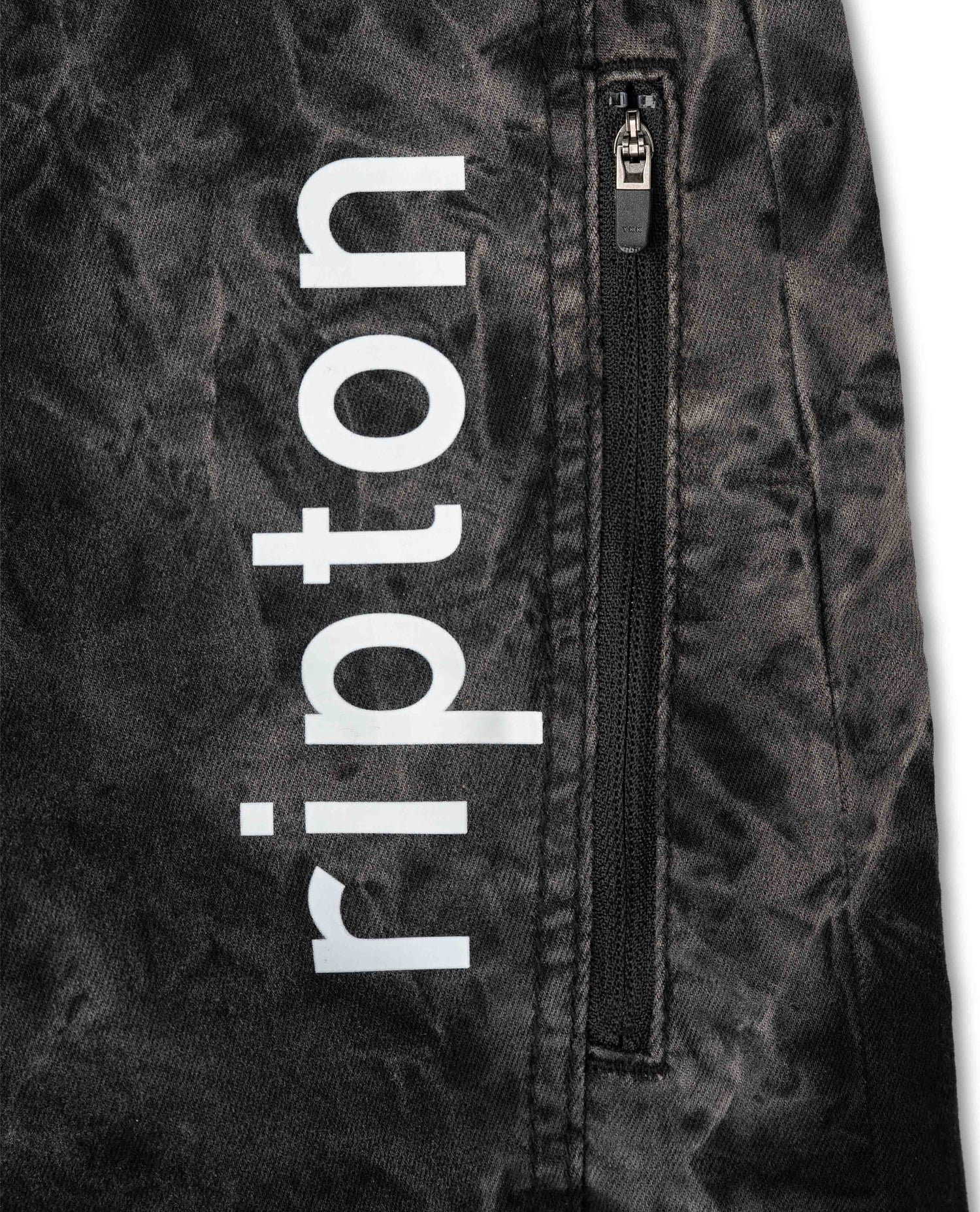 Close-up of a jacket with 'ripton' branding on a textured background