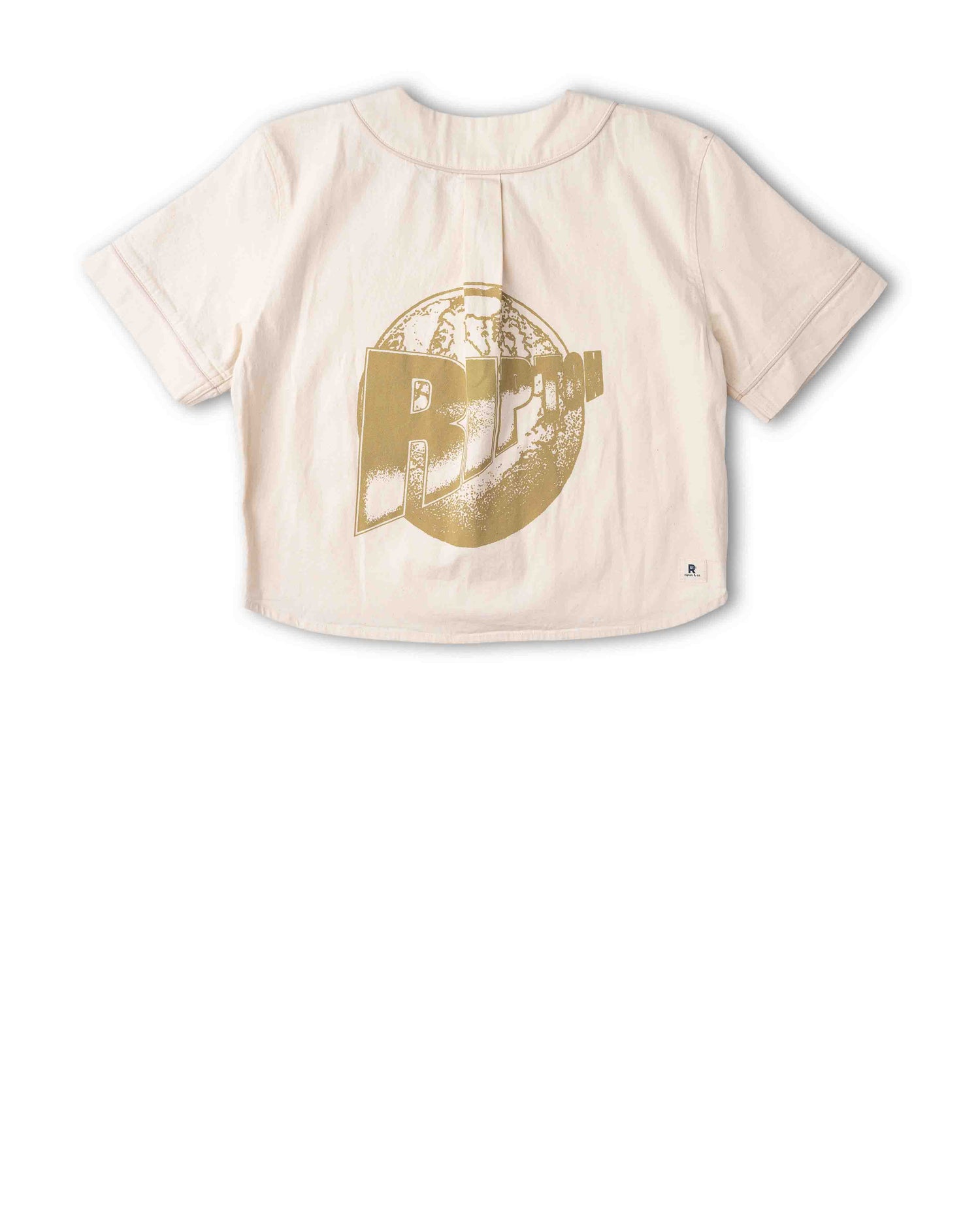 A short-sleeve t-shirt in a light cream or pale pink color, featuring a large distressed gold graphic of a building with the word 'BIPOLAR' on the front, displayed against a solid white background.