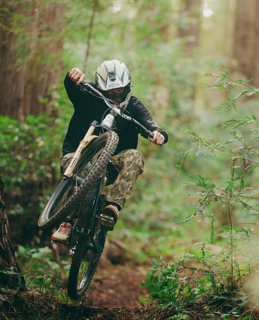 Person riding a mountain bike through a forest