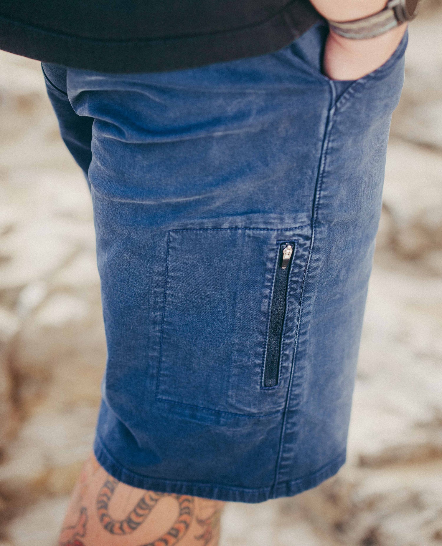 Close up of zipper pocket on blue twill shorts