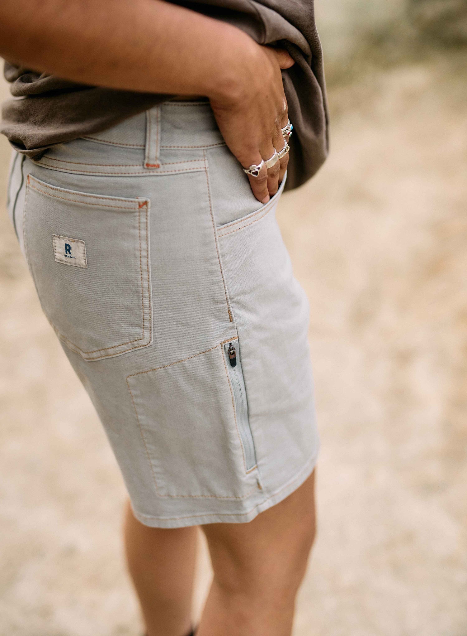 Light denim skirt worn by a person with a blurred natural background