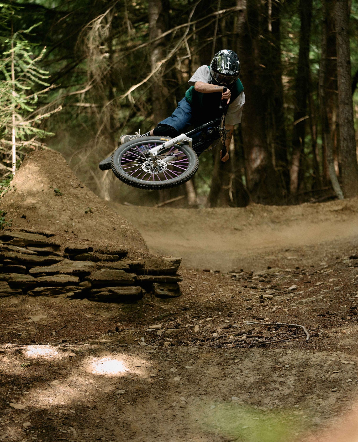 Person on a bicycle performing a jump in a forest setting