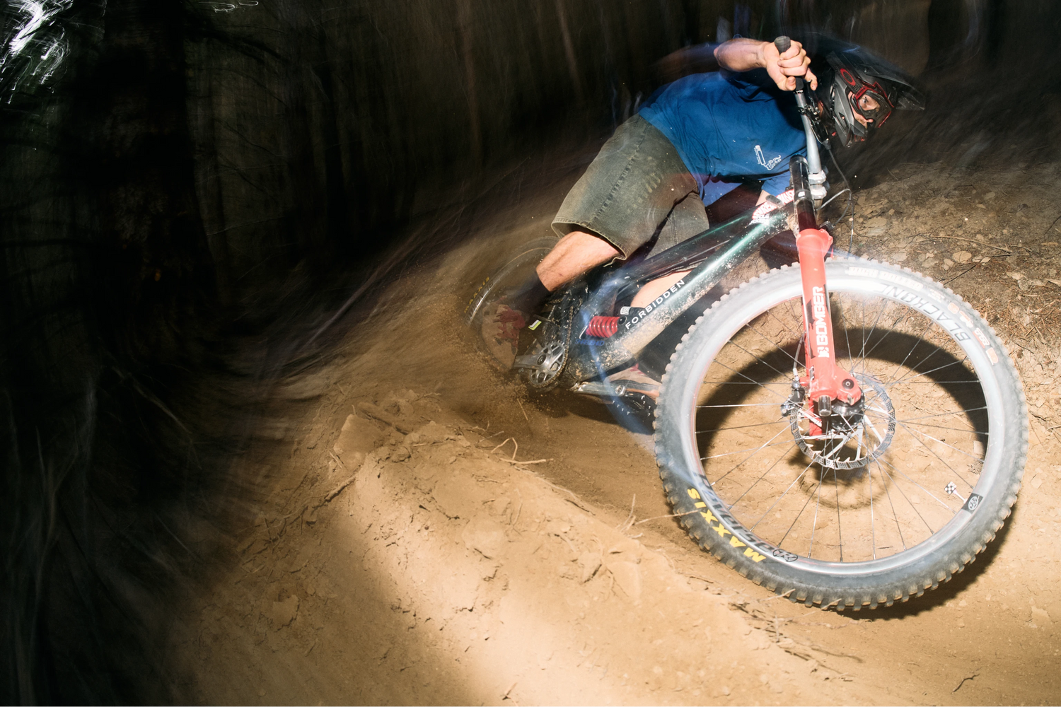 Person riding a mountain bike on a dirt trail at night