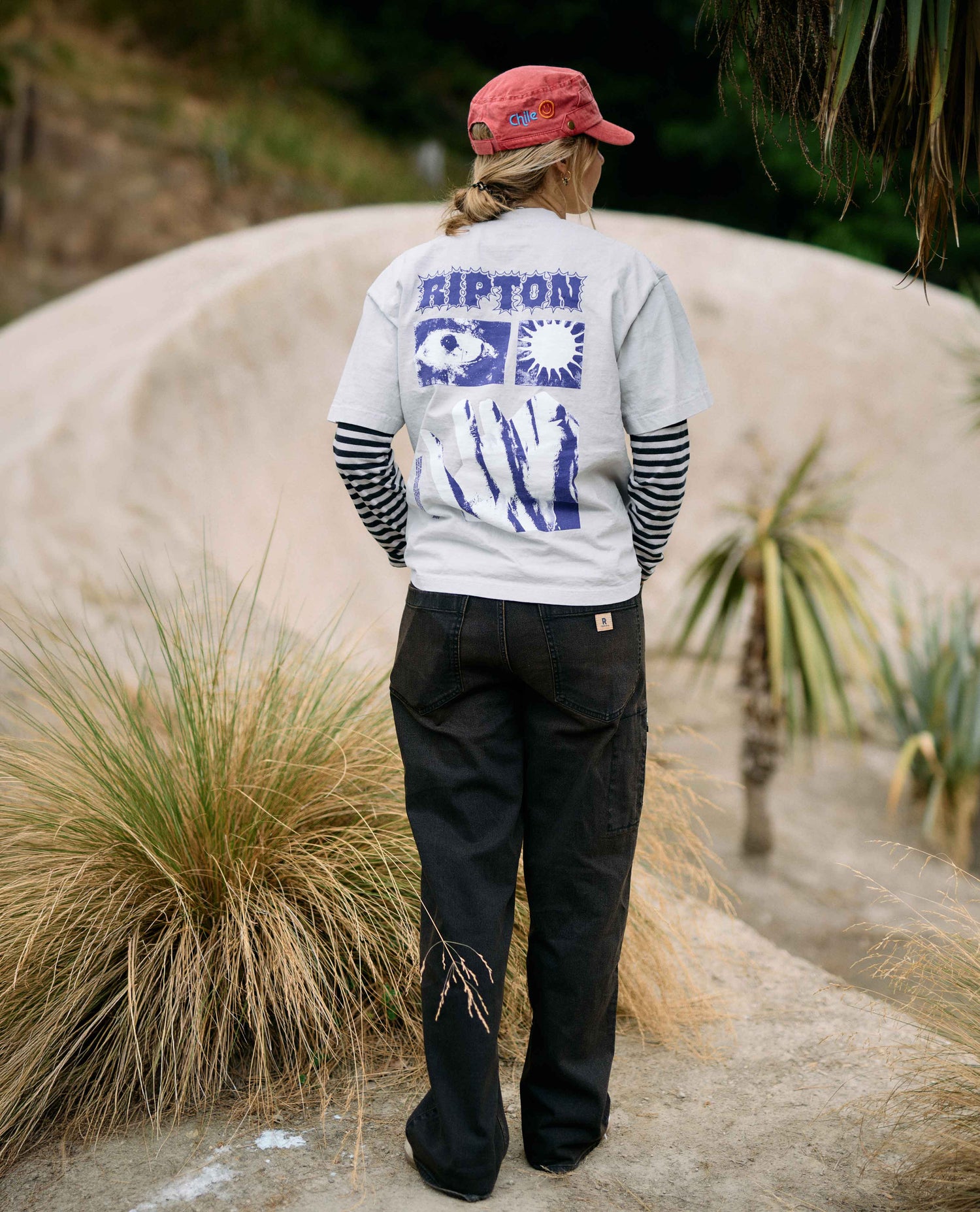 Person wearing a gray sweatshirt with 'Ripton' branding in a natural setting